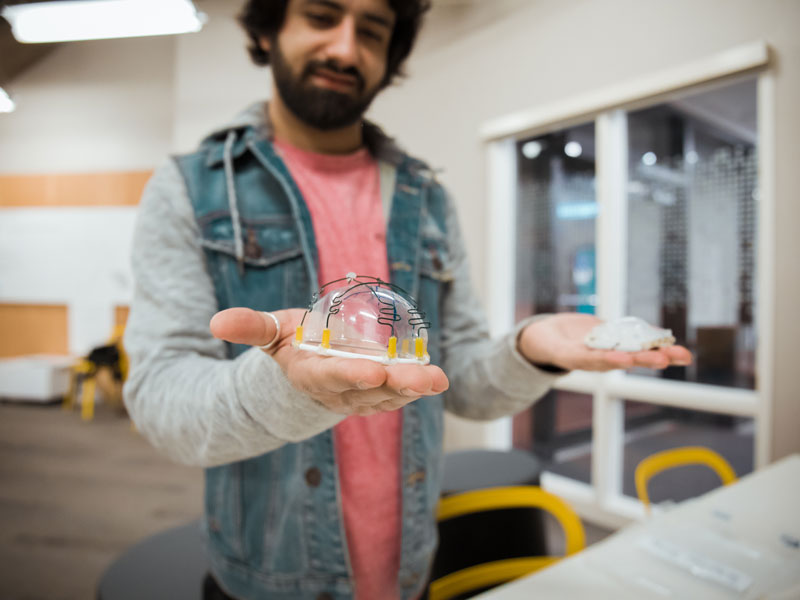 Student holding a model of a project he designed.